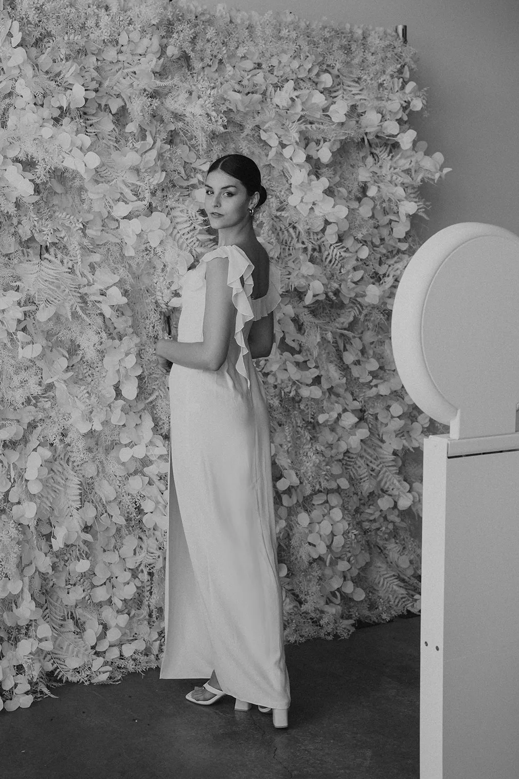 Photo booth set up beside a white floral wall