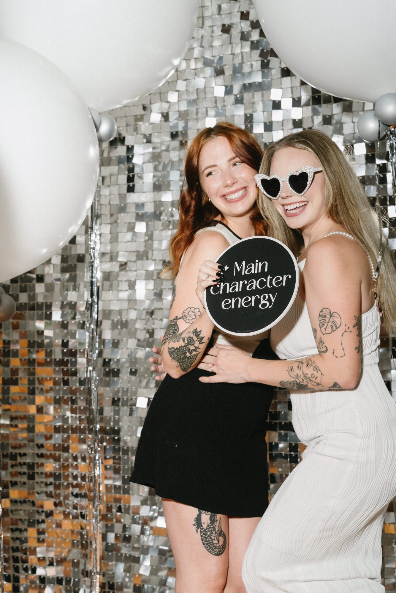 Two guests posing beside a photo booth